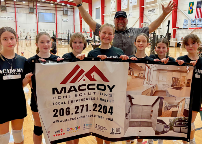 Young women holding MacCoy Home Solution's banner